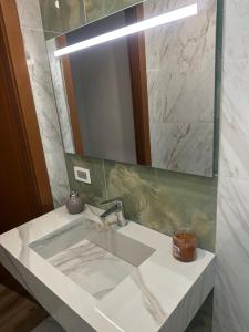 a bathroom with a sink and a mirror at Aer in Caserta +18 photos
