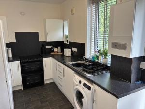 a kitchen with a sink and a dishwasher at Kilnhill in Hawick