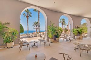 a lobby with tables and chairs and palm trees at Bahia Principe Escape Tenerife - Hyatt Inclusive Collection in Adeje