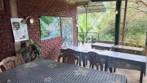 a restaurant with tables and chairs and a brick wall at Forest Rawana homestay Ella in Ella