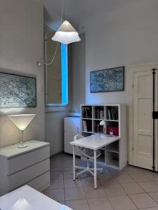 a room with a desk and a table and a window at Gabici Suite Ravenna in Ravenna +2 photos