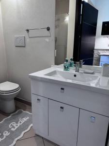 a bathroom with a white sink and a toilet at Gabici Suite Ravenna in Ravenna