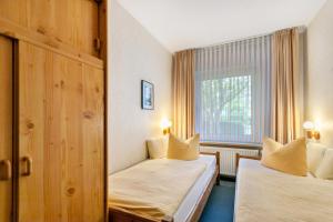 a hotel room with two beds and a window at Haus Passat in Büsum