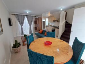 a dining room with a wooden table and blue chairs at Casa full equipada con tres camas y se puede habilitar una cuarta cama a solicitud in Antofagasta
