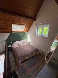 a bedroom with a bed in a room with a window at Le chalet de l Escaut in Bantouzelle