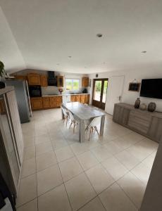 a kitchen with a white table and a white tile floor at Le chalet de l Escaut in Bantouzelle
