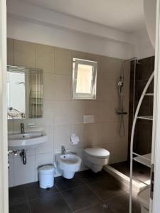 a bathroom with a sink and a toilet and a shower at Roberts Villa in Dhërmi +31 photos