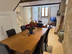 a dining room table with a vase of flowers on it at Maison Girasol Sleeps 4 w Pets On Request in Eymet