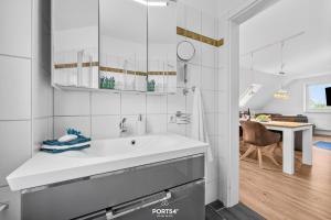a white bathroom with a sink and a dining room at Ferienwohnung Lee Dagebüll in Dagebüll +16 photos