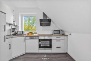 a kitchen with white cabinets and a stove top oven at Ferienwohnung Lee Dagebüll in Dagebüll