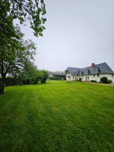 a large green yard with a large house at Le Clos des Argillières in Le Perrey