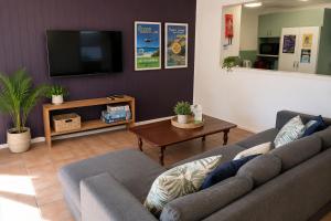 a living room with a couch and a tv at Pippies Beachhouse Backpackers in Rainbow Beach