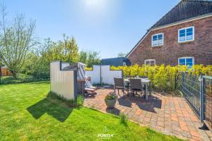 a backyard with a table and chairs and a fence at Ferienwohnung Lee Dagebüll in Dagebüll