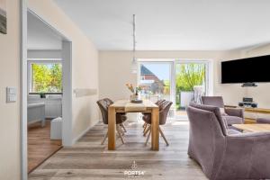 a dining room and living room with a table and chairs at Ferienwohnung Luv Dagebüll in Dagebüll