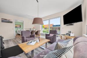 a living room with a couch and a table at Ferienwohnung Luv Dagebüll in Dagebüll +24 photos