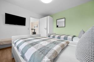 a bedroom with two beds and a flat screen tv at Ferienwohnung Luv Dagebüll in Dagebüll