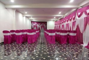 a room with a bunch of pink chairs in it at HKS Orchards Stay in Kanatal