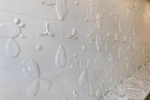 a wall covered in white leaves on a wall at Plus Fariones Habitat in Arrecife