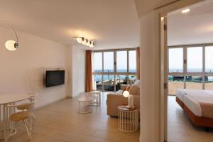 a bedroom with a bed and a living room at Plus Fariones Habitat in Arrecife +15 photos