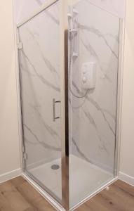 a shower with a glass door with a wall at Glentorran in Campbeltown