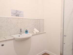 a white bathroom with a sink and a shower at Glentorran in Campbeltown +6 photos