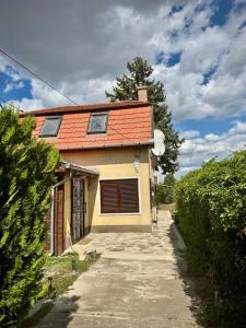 a small yellow house with an orange roof at Apacs Villa in Ráckeve