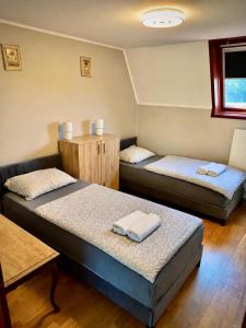 a room with two beds and a table at Apacs Villa in Ráckeve +17 photos