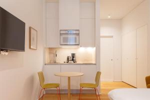 a small kitchen with a table and two chairs at LSA Estrela by Numa in Lisbon +58 photos