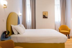 a hotel room with a bed and a chair at LSA Estrela by Numa in Lisbon