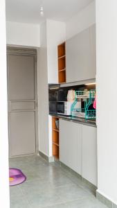 a kitchen with white cabinets and a refrigerator at Stylish 10th Floor Studio with great Views ,Fast Wi-Fi and Secure in Nairobi