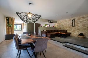 a living room with a dining table and a couch at Superbe maison au calme - Piscine in Chantraine