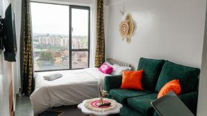 a living room with a green couch and a bed at Stylish 10th Floor Studio with great Views ,Fast Wi-Fi and Secure in Nairobi +50 photos