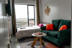 a living room with a green couch and a bed at Stylish 10th Floor Studio with great Views ,Fast Wi-Fi and Secure in Nairobi