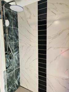 a bathroom with a shower with black and white marble at Acasa do Delco Accommodatiion in Welkom +11 photos