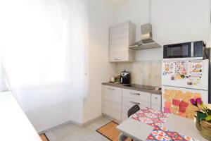 a kitchen with a white refrigerator and a table at Casa Teresa in Rome