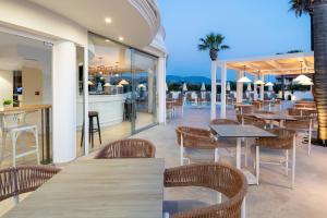 a restaurant with tables and chairs and a bar at Arkadia Hotel in Kypseli