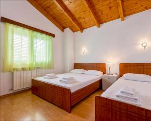 two twin beds in a room with a window at Countryside Villa in Vlorë