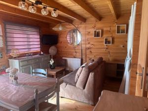 a living room with a couch and a table at " domaine des chevrettes chalet cosy au cœur des châteaux " in Cour-Cheverny