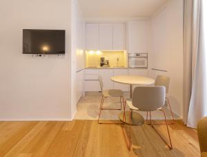 a living room with a table and chairs and a kitchen at LSA Estrela by Numa in Lisbon