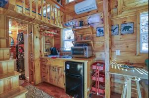 a log cabin kitchen with a stove and a microwave at Peaceful Forest Tiny Home in Newport