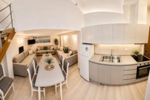 a kitchen and living room with a couch and a table at Flors Apartments in Durrës