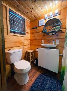a wooden bathroom with a toilet and a sink at Peaceful Forest Tiny Home in Newport