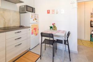 a small kitchen with a table and a refrigerator at Casa Teresa in Rome