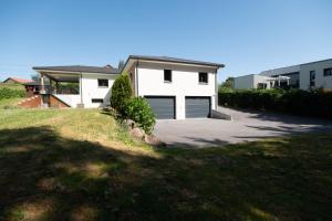 a white house with a driveway at Superbe maison au calme - Piscine in Chantraine