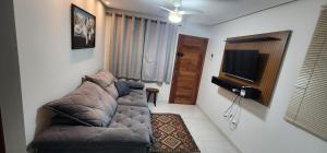 a living room with a couch and a flat screen tv at Casa em São Mateus - Guriri in São Mateus