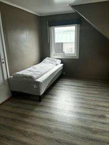a small bedroom with a bed and a window at Bedify Lodge Sokndal in Sokndal