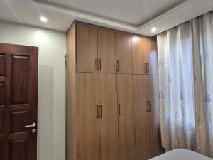 a bedroom with wooden cabinets next to a bed at CozyStay Homes in Kampala