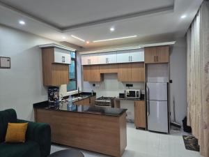 a kitchen with wooden cabinets and stainless steel appliances at CozyStay Homes in Kampala +4 photos