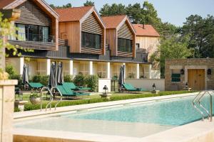 a villa with a swimming pool in front of a house at Hostellerie De Levernois in Levernois