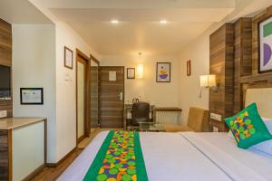 a hotel room with a bed and a desk at Treebo Aaram Orchard in Ahmedabad +44 photos